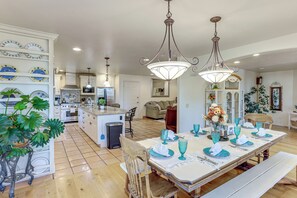 A spacious kitchen with a central island, modern appliances, and a dining area set for six with blue glassware. - Spacious Escape Near Mesa Verde National Park! (Mancos)