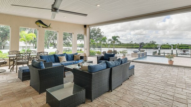 An outdoor patio area with wicker furniture, a ceiling fan, and a view of a water body. - Waterfront Arcadia Home w/ Dock on Peace River (Fort Ogden)