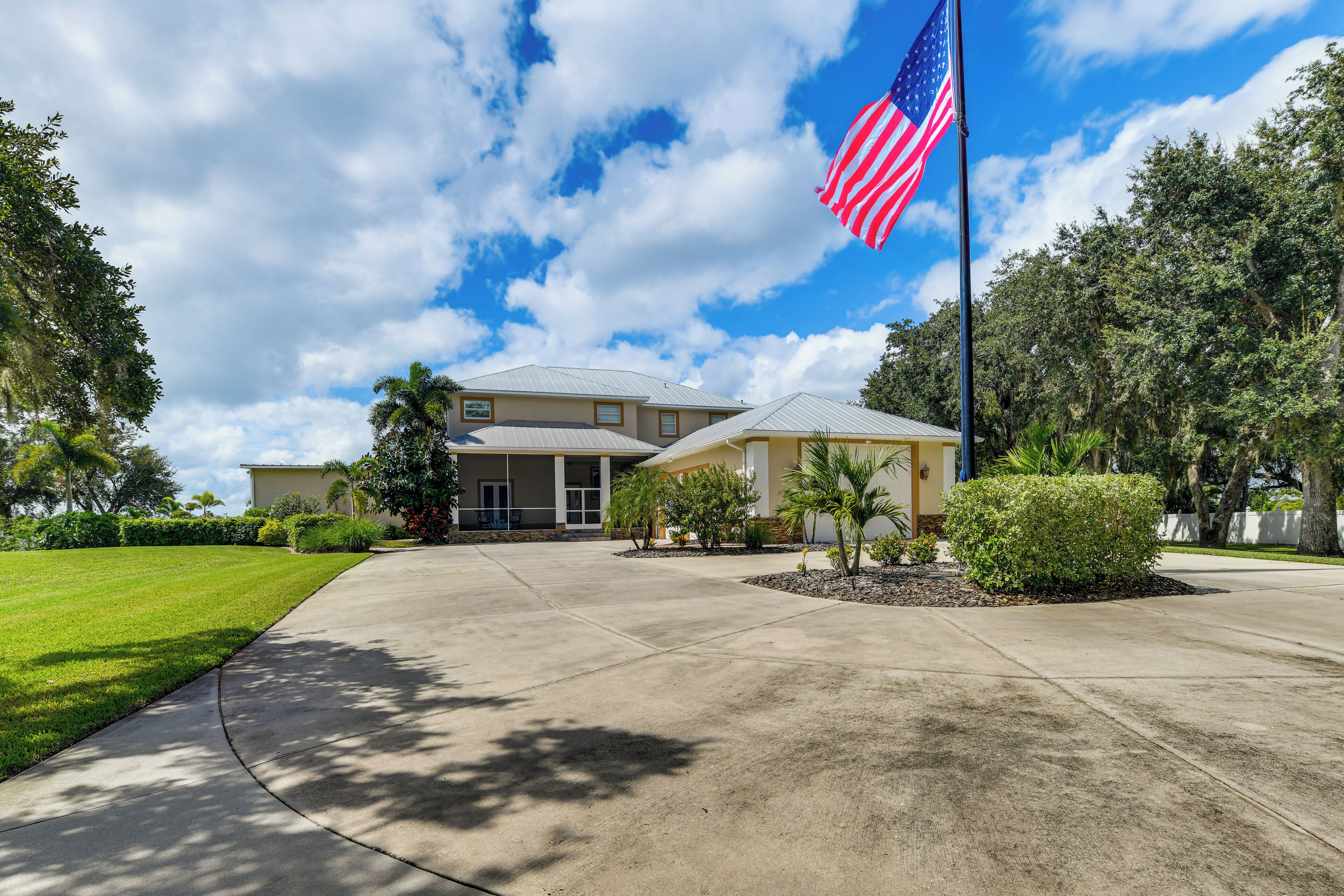 A two-story building with a flagpole, a well-maintained lawn, and a clear sky.