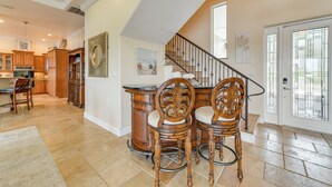 A spacious kitchen with wooden cabinets and a dining area with a bar and four chairs. - Waterfront Arcadia Home w/ Dock on Peace River (Fort Ogden)
