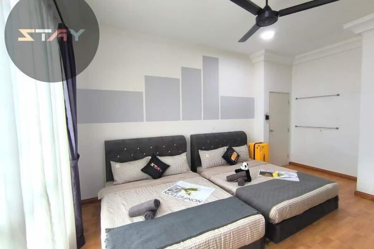 A bedroom with two beds, a ceiling fan, and a wall with a geometric design.