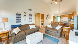 A spacious living room with two brown sofas, a coffee table, and a kitchen in the background. - 13 Mi to South Haven: Lakefront Retreat w/ Dock! (Grand Junction)