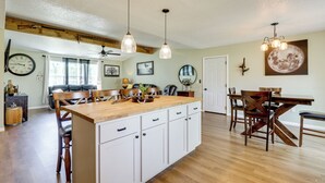 A spacious kitchen with wooden countertops, white cabinets, and a central island. There are hanging pendant lights and a ceiling fan. - Ozark Getaway Near Roaring River & Fishing (Cassville)