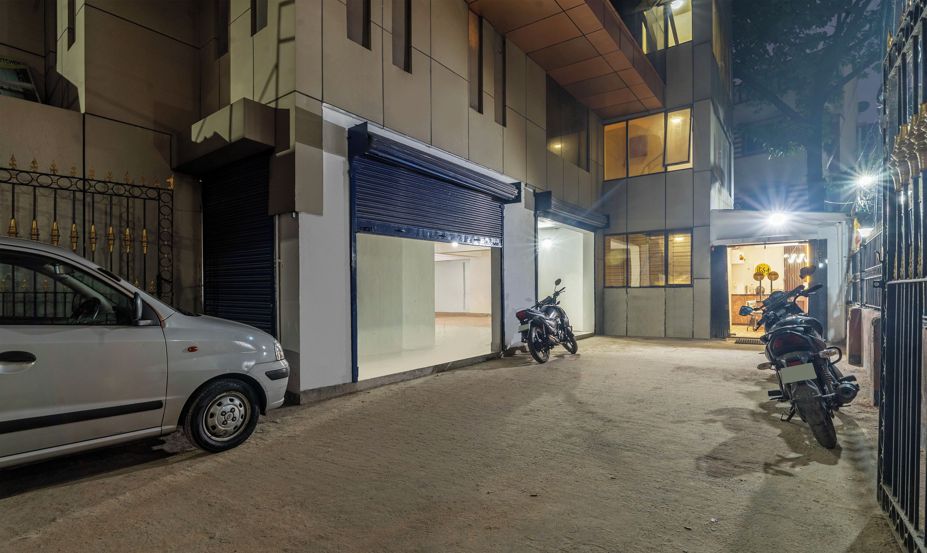 Un edificio con una tienda cerrada y dos motocicletas estacionadas frente a él.