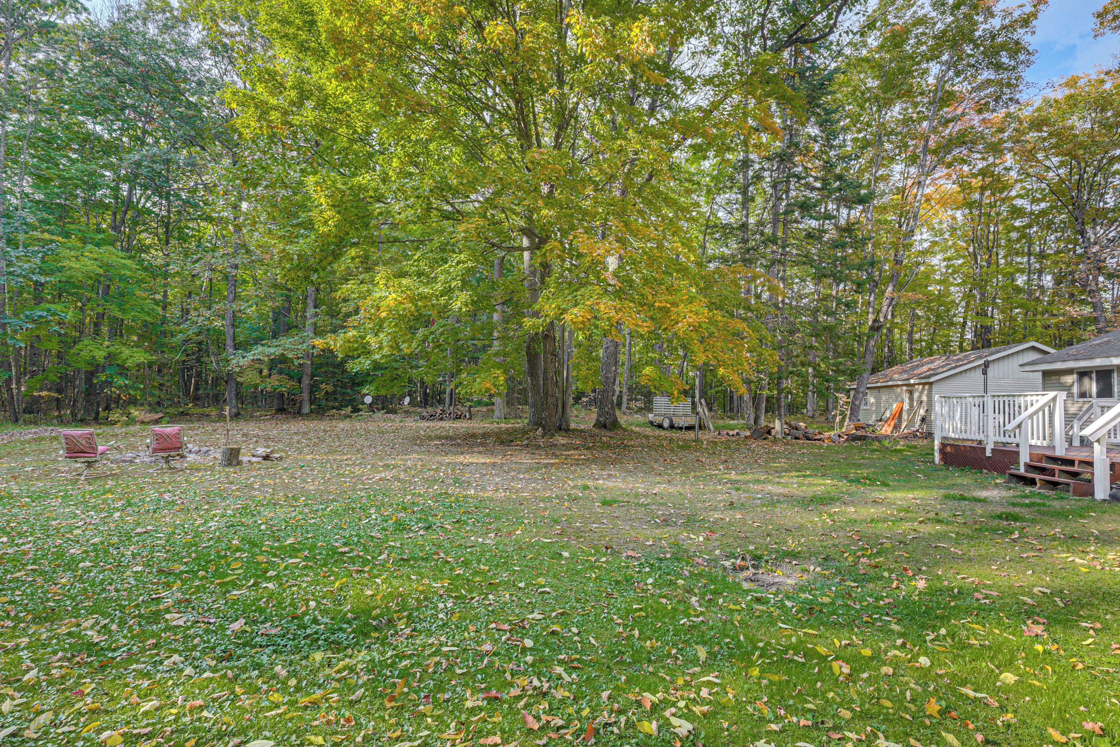 A residential area with a grassy yard, a wooden deck, and a house with a porch.