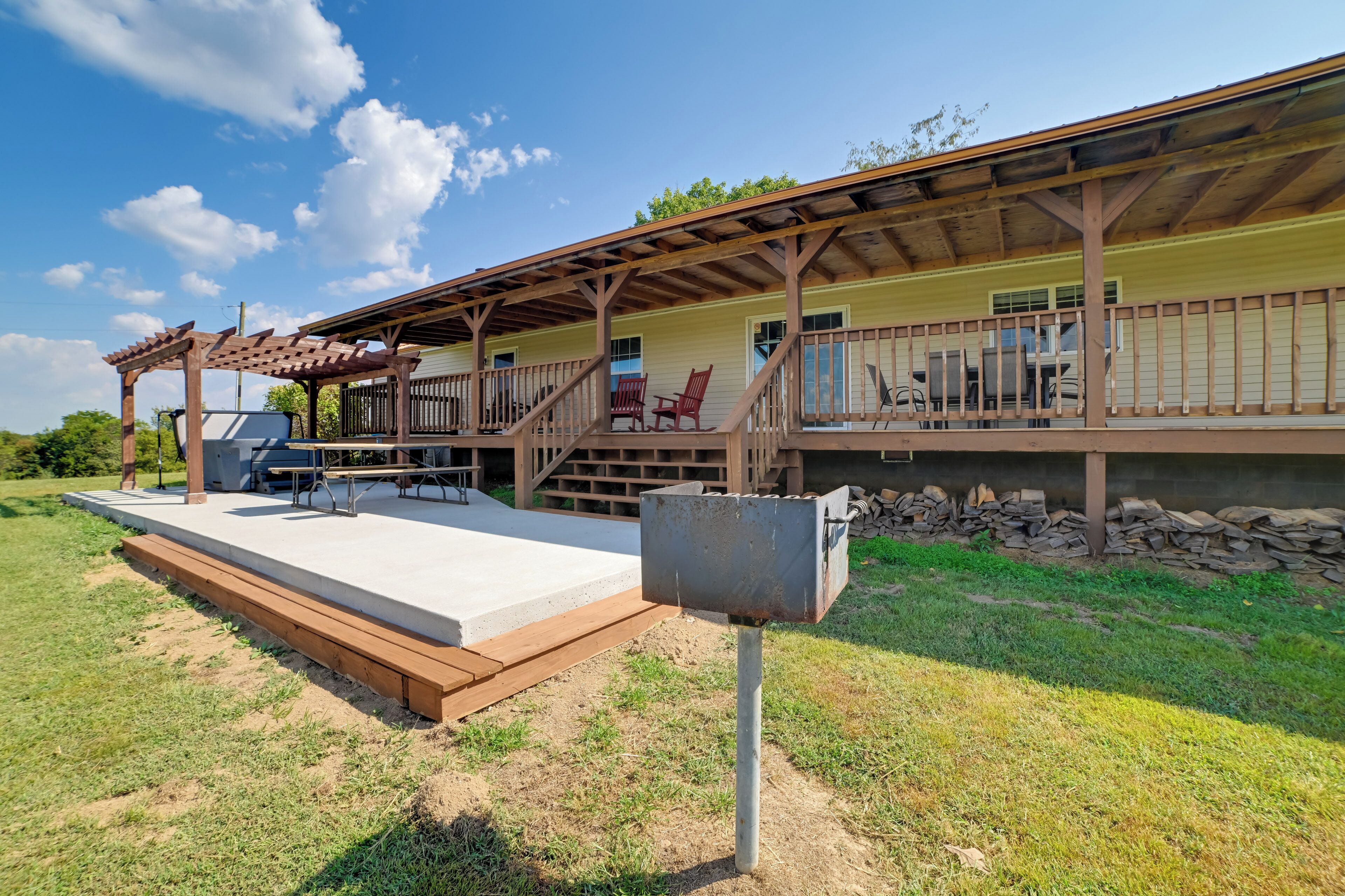 A covered outdoor area with a concrete platform, wooden deck, and a metal mailbox.