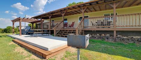 A covered outdoor area with a concrete platform, wooden deck, and a metal mailbox.