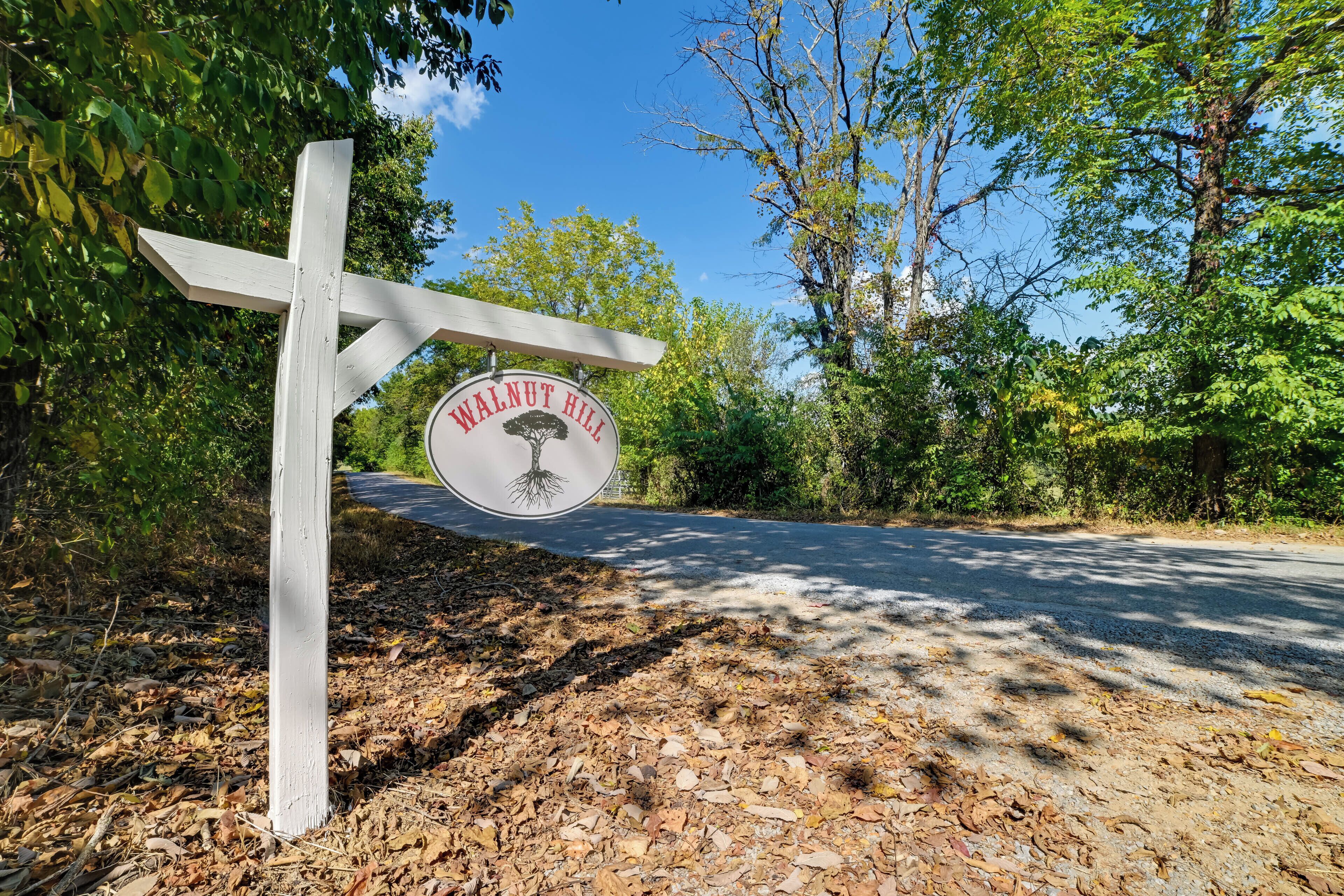 A wooden signpost with a circular sign reading "Walnut Hill" and a tree symbol.