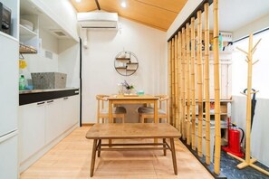 Une cuisine compacte comprenant une table à manger, des chaises et un banc en bois.