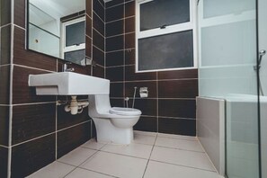 A modern bathroom with a white toilet, a sink, and a glass shower enclosure. - Encorp Marina Residences Puteri Habour (Iskandar Puteri)