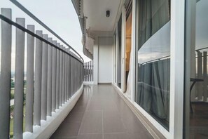 Ein Korridor mit Geländer, einer Tür und einem fensterbepflanzten Fenster.