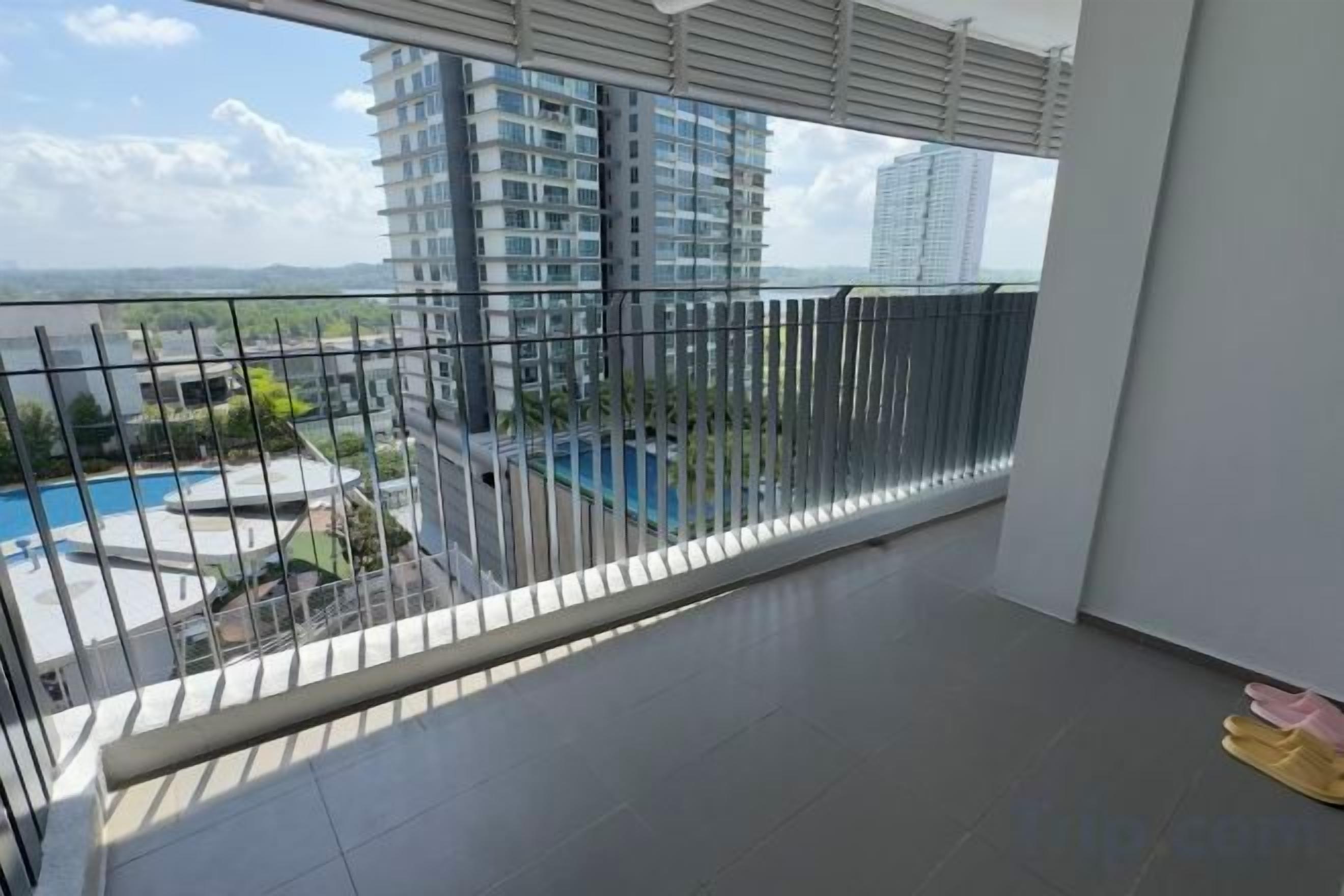 Un balcon donnant sur une piscine et des immeubles de grande hauteur.