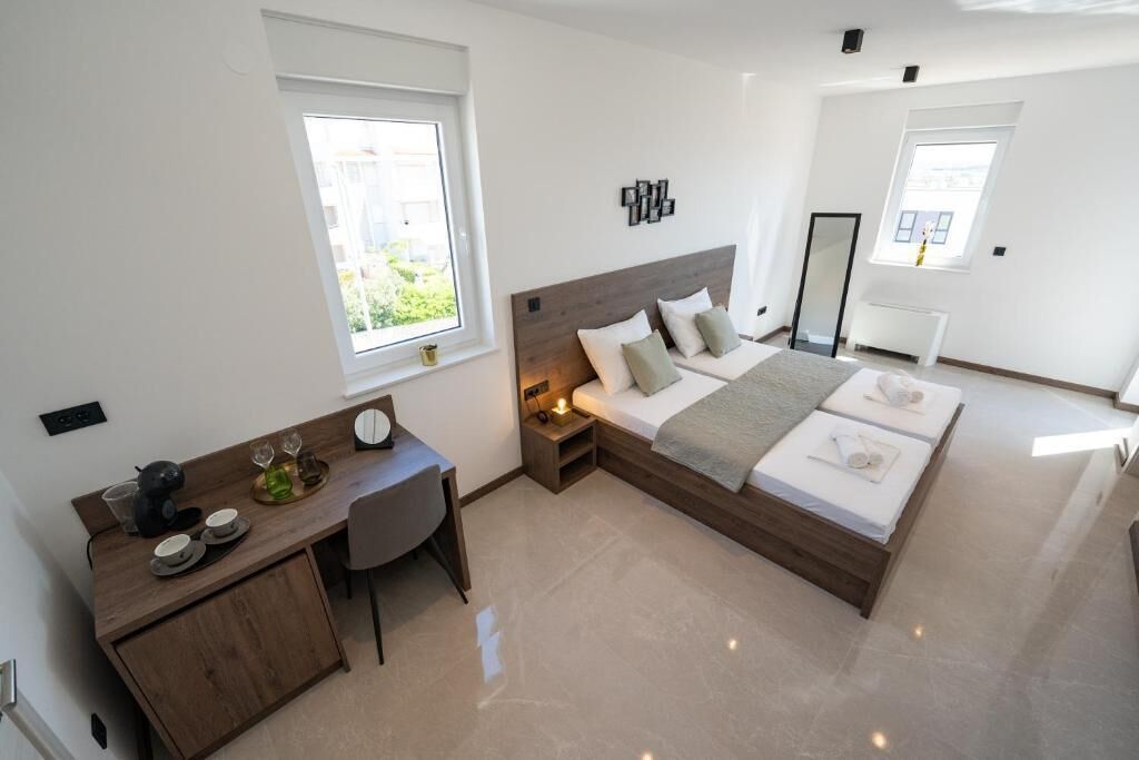 Un dormitorio moderno con cama, mesita de noche y zona de escritorio con silla.