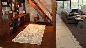 A modern loft with exposed wooden beams, a built-in desk, and a staircase leading to an upper level. - The Residence- A home away from home. Pet friendly/ family friendly. (Jindalee)