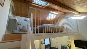 A loft-style bedroom with a skylight, a bathroom with a shower, and a dining area with a TV. - Termoli - Casa Vacanza - BASTIONI QUATTRO (Termoli)