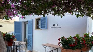 A balcony with blue shutters, a table, and potted plants. - Termoli - Casa Vacanza - BASTIONI QUATTRO (Termoli)