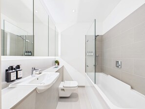 Une salle de bain moderne avec un grand lavabo, des toilettes et une baignoire.