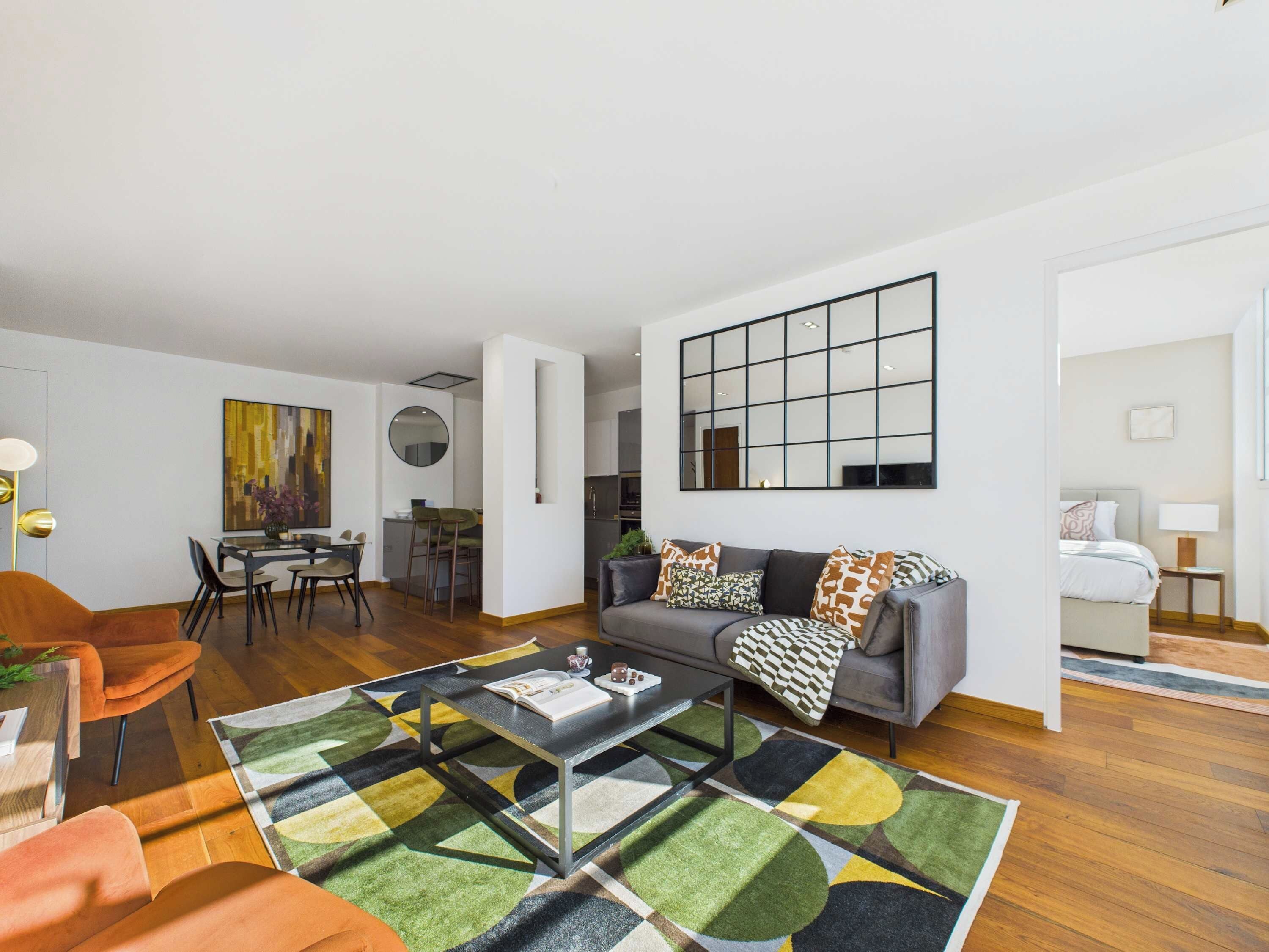 Una sala de estar moderna con un sofá, una mesa de centro y una zona de comedor con sillas y una mesa.