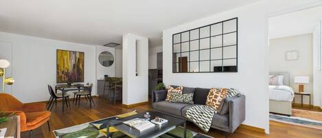 Una sala de estar moderna con un sofá, una mesa de centro y una zona de comedor con sillas y una mesa.