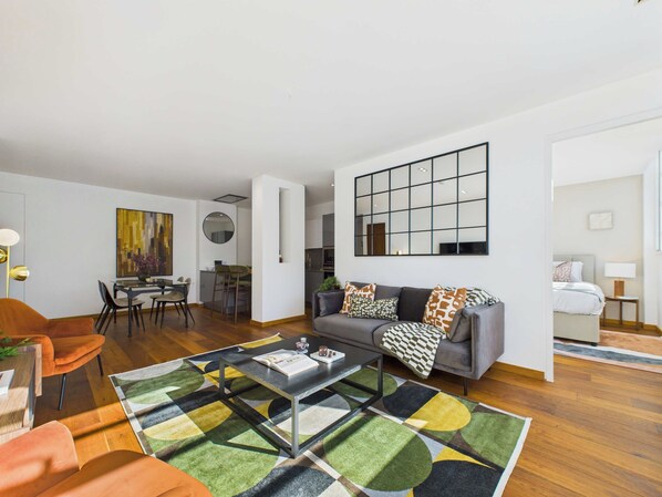 Una sala de estar moderna con un sofá, una mesa de centro y una zona de comedor con sillas y una mesa.