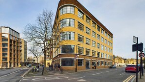 Un bâtiment moderne doté d’une façade incurvée, de grandes fenêtres et d’une façade en briques.