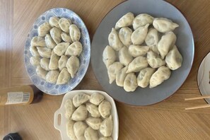 Three plates of dumplings on a wooden table. - QIN DUN JU (Dammam Principality)
