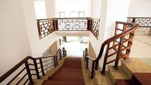 Un escalier avec des rampes en bois et un motif décoratif sur le sol.