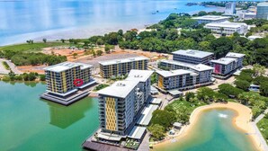 Ein Küstenhotel mit mehreren Gebäuden, einem Strand und einem Yachthafen.