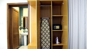 A wooden wardrobe with a hanging iron and a small shelf. - Rafa Serviced Apartments - Economic (Riyadh)