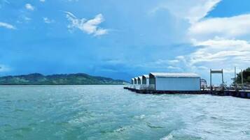Una estructura flotante con varias habitaciones sobre el agua, conectada por un embarcadero.