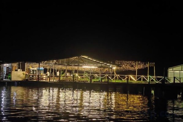 A waterfront building with a covered outdoor area, possibly a restaurant or bar, with a view of the water in the foreground. - Seawind semporna water village resort (Semporna)