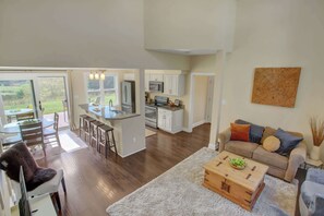 A spacious living area with a kitchen, dining area, and a cozy seating area with a sofa and a coffee table.