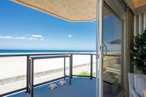 Un balcon avec vue sur la plage et l’océan.