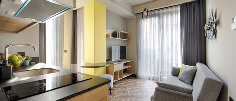 A modern kitchen with a built-in stove, a sink, and a yellow accent wall.