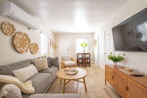 A living room with a sofa, coffee table, and TV stand.