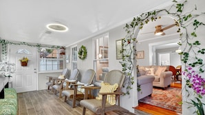 A cozy living room with a fireplace, comfortable seating, and a view of the outdoors. - Walk to Downtown Mount Dora! Patio Oasis + King Bed! (Mount Dora)