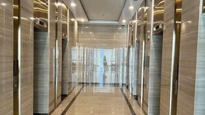 A modern elevator lobby with reflective floors and walls, and a central glass partition. - Nanahousing-Nice Apartment near Korea Town & Chinese Area (Hanoi)
