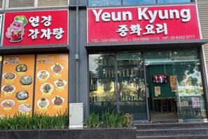 A restaurant with a red signboard and a menu board displaying various dishes. - Nanahousing-Nice Apartment near Korea Town & Chinese Area (Hanoi)