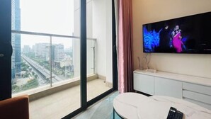 A modern hotel room with a large window, a flat-screen TV, and a minimalist design. - Nanahousing-Nice Apartment near Korea Town & Chinese Area (Hanoi)