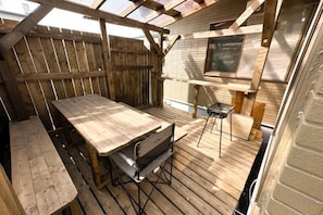 A wooden deck with a table and chairs, a wooden fence, and a brick wall. - HAGINOTCHI (Shiraoi District)