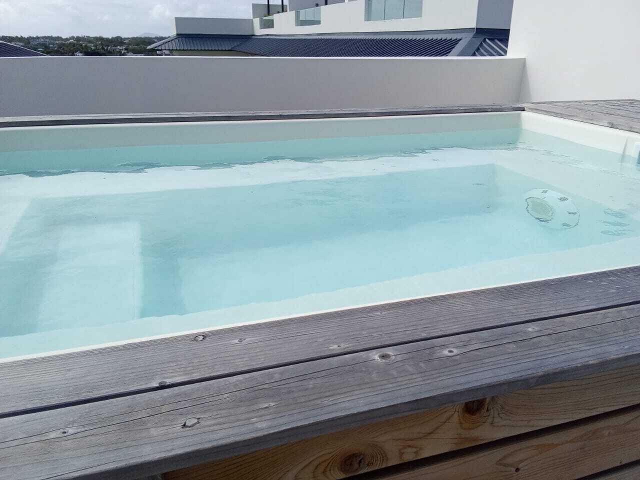 A rectangular swimming pool with a wooden deck edge.