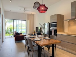 Una cocina moderna con comedor, un amplio ventanal y vistas a zonas verdes.