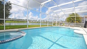 A covered swimming pool with a view of a lake and palm trees. - Lakeside Villa 5 Bedroom Home (Davenport)