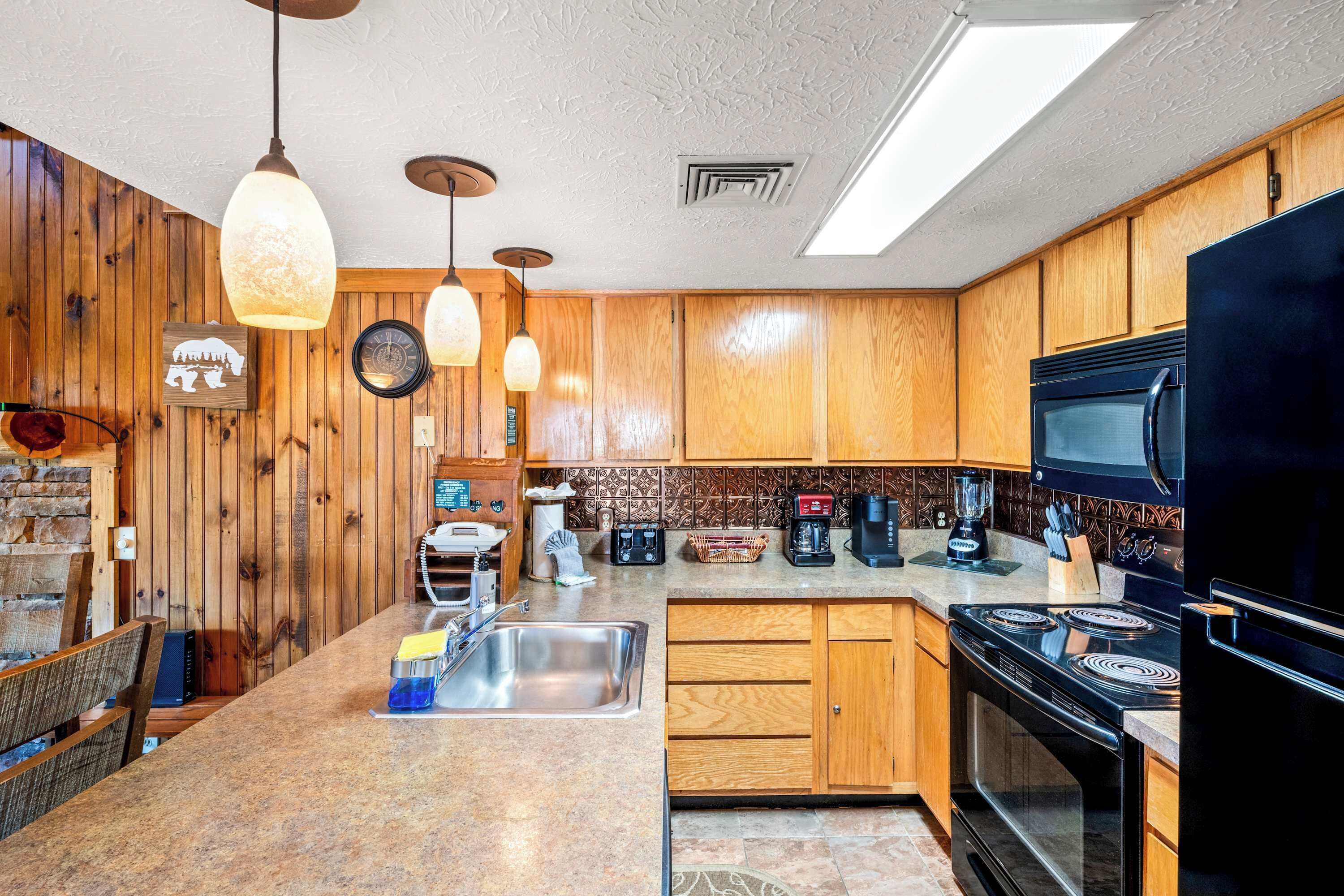 A kitchen with wooden cabinets, a black refrigerator, a stove, and a sink.