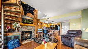 A cozy living room with a fireplace, wooden walls, a dining area, and a comfortable seating area. - Mountain Top View in Gatlinburg (Gatlinburg)