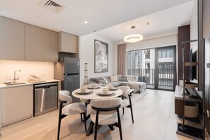 A modern apartment with a kitchen, dining area, and living room. - Dubai Creek Harbour Sleeps 4 With Private Balcony (Dubai)