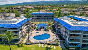 Un hôtel doté d’une piscine centrale, de nombreux balcons et offrant une vue sur le paysage environnant.
