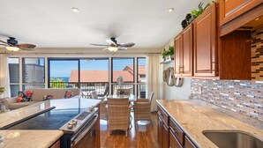 Una cucina moderna con una grande isola, mobili integrati e vista sull'esterno.