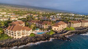 A coastal resort with multiple buildings, a rocky shoreline, and a swimming pool.