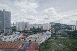 A cityscape with high-rise buildings, a large open building with multiple roofs, and a hilly background. - M Vertica Tower A Tower A by FEEL HOME (Kuala Lumpur)